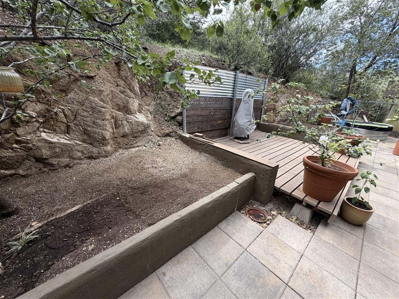 Stucco retaining wall and raised planter built into a rocky hillside near Prescott